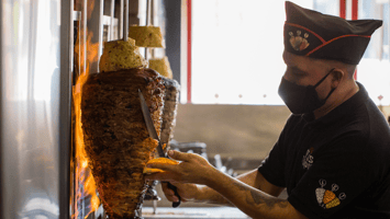 hombre preparando un taco al pastor 