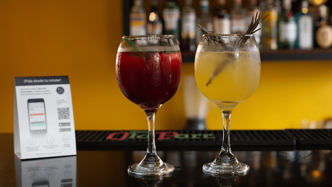 Dos copas con cócteles de frutas sobre una barra de restaurante. 