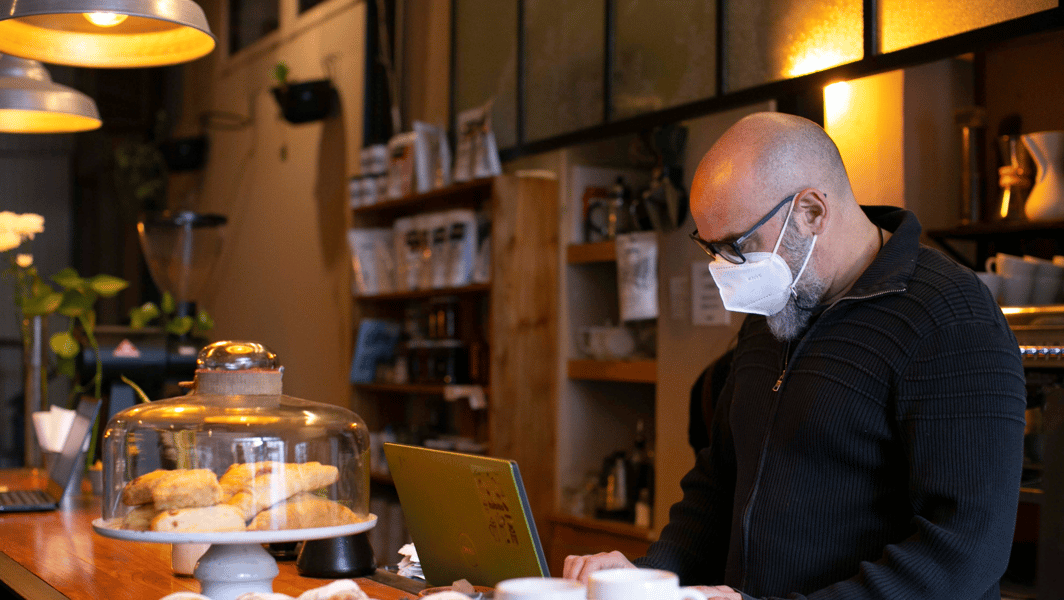 Hombre utilizando una computadora en su cafetería